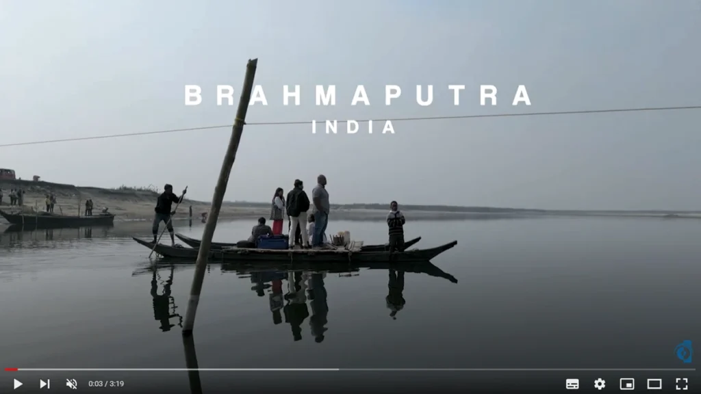 Video screenshot with title "Brahmaputra India" over people on a boat on a river.